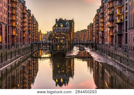 The Historic Speicherstadt With The Wasserschloss In Hamburg, Germany, After Sunset