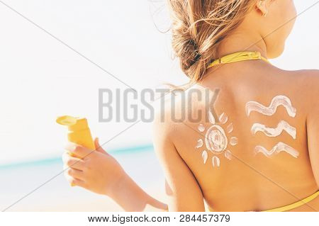 Child On The Beach Smears Sunscreen. Selective Focus.