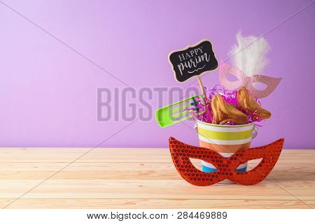 Jewish Holiday Purim Background With Bucket, Carnival Mask, Noisemaker And Hamantaschen Cookies On W