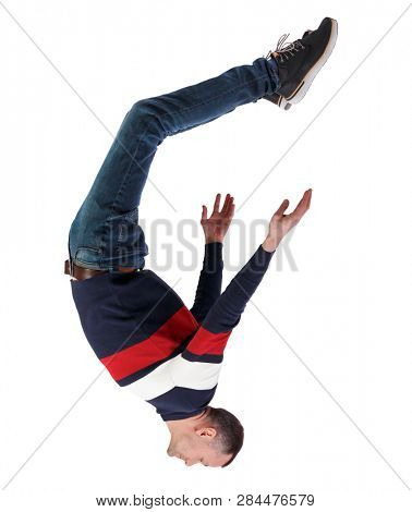 Side view of man in zero gravity or a fall. guy is flying, falling or floating in the air.  side view of person.  Isolated over white background. The guy in the jacket falls upside down.