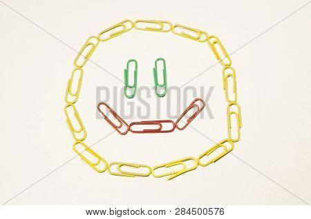 Colored Paperclips In The Shape Of The Smiling Face Isolated On The White Background. Stay Happy And