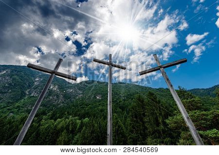 Three Religious Crosses In Mountain With Blue Sky, Clouds And Sun Rays. Pinzolo, Trentino Alto Adige