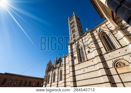 Siena Cathedral, Santa Maria Assunta 1220-1370 With Clear Blue Sky And Sun Rays. Tuscany, Italy, Eur
