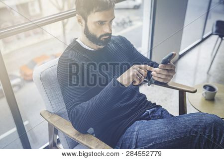 Handsome Bearded Caucasian Man In Black Pullover Using Mobile Phone Application For Mobile Blogging.