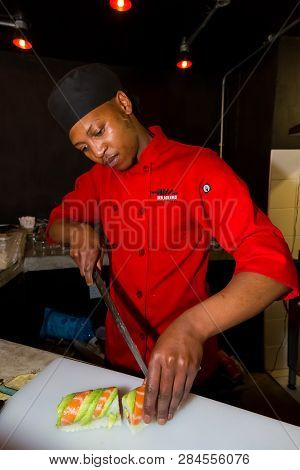 Johannesburg, South Africa - September 28 2014: Chef  Preparing A Fresh Roll Of Sushi