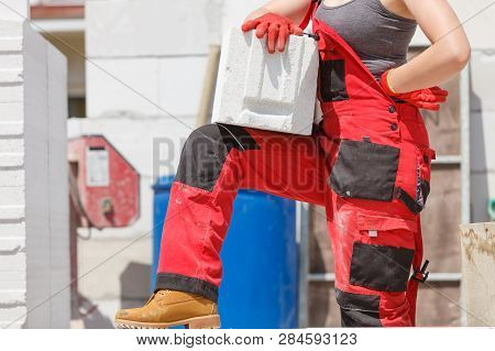 Unrecognizable Woman Working On Construction Site, Building House, Installing Gray Airbricks. Indust