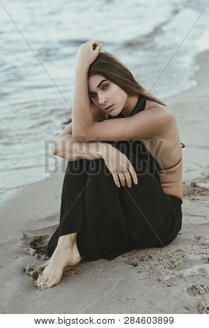 Beautiful Thoughtful Woman With Golden Frackles Sitting On The Beach