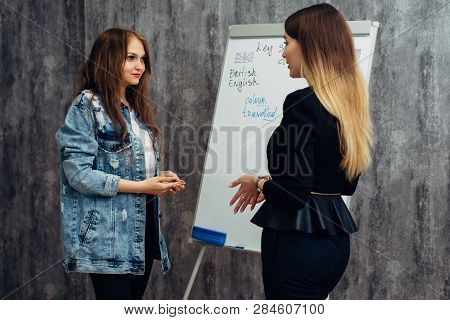 English Language School. Two Female Students Talking In Classroom.