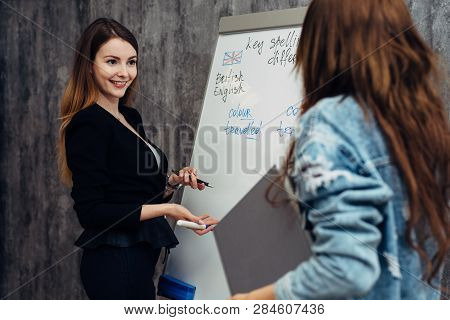 English Language School. Two Female Students Talking In Classroom.