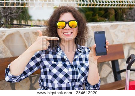 Technology, Emotions And People Concept - Happy Young Woman In Sunny Glasses Show Her Mobile Phone