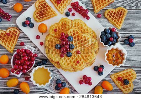 Delicious Homemade Waffles. Waffles Like Heart, Fresh Berries, Honey And Jam On A White Dish