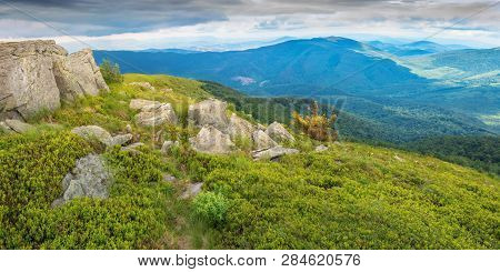 Panorama With Massive Rocks On A Grassy Meadow. Beautiful Summer Landscape In Mountains. Overcast Sk