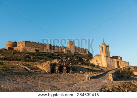 The Church Of Santiago Apostol And The Castle Of Medellin Seen At Sunset, Extremadura, Spain.