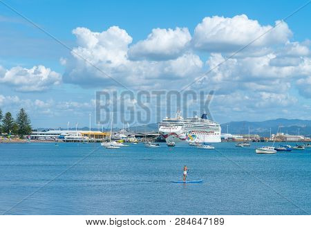 Mount Maunganui New Zealand - February 8 2019: Woman Paddleboards Across Pilot Bay While Huge Cruise