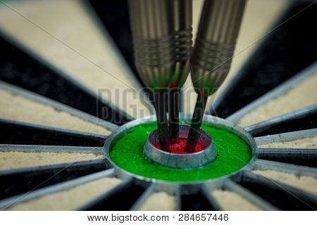 Macroshot Of Three Darts In The Bulls Eye Of A Dartboard