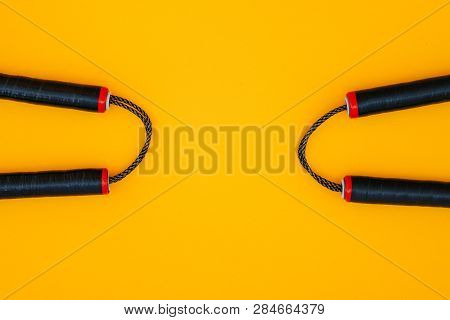 Two Nunchats On A Yellow Background, Flat Lay. Nunchaku For Training