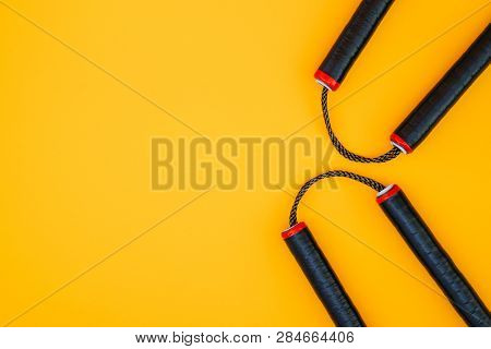 Asian Nunchaku Weapon On A Yellow Background And A Place For Text. Flat Lay