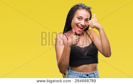 Young braided hair african american with pigmentation blemish birth mark over isolated background doing happy thumbs up gesture with hand. Approving expression looking at the camera
