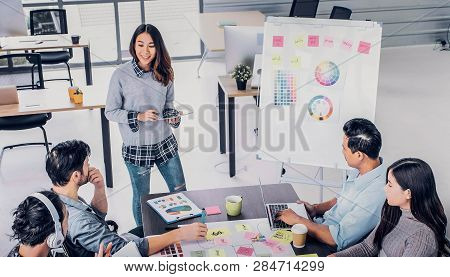 Female Creative Director Team Lead Brainstrom Branding Project With Designer Team At Meeting Table.d