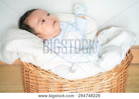 Infant Baby Lying On Blanket In Wood Baket On White Background