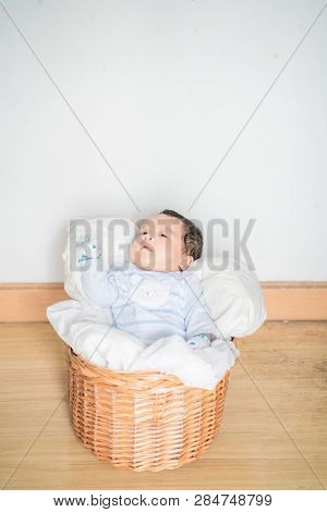 Infant Baby Lying On Blanket In Wood Baket On White Background