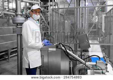 Technologist Taking Necessary Notes While Standing At Production Department Of Dairy Factory