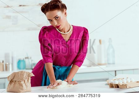 Pritty Pin Up Girl Kneading Dough And Looking At Camera