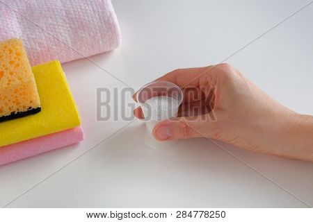Cleaning Concept. Detergent For Cleaning Room. Hand Holding A Plastic Measuring Cup With Granular Cl