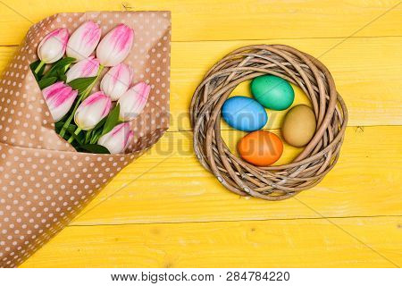 Spring Vibes. Colorful Eggs And Bouquet Fresh Tulip Flowers On Yellow Background Top View. Spring Ho