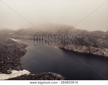 Lakes In Stone Rocky Mountains, Misty Foggy Day. Norway Summer Landscape. Norwegian National Tourist