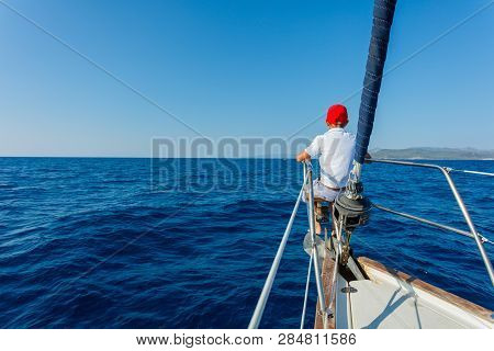 Little Boy On Board Of Sailing Yacht On Summer Cruise. Travel Adventure, Yachting With Child On Fami