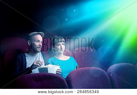 Teenager couple cuddling and watching the climax part of the movie