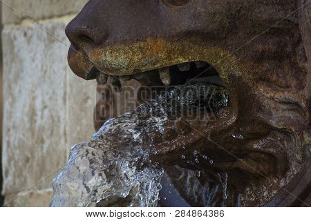 Photo Of A Fountain With Water, Rusty Metal And Sunlight
