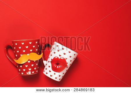 Couple Of Red Cup With Mustache And White Cup With Lips Painted With Hearts On Vibrant Background. V
