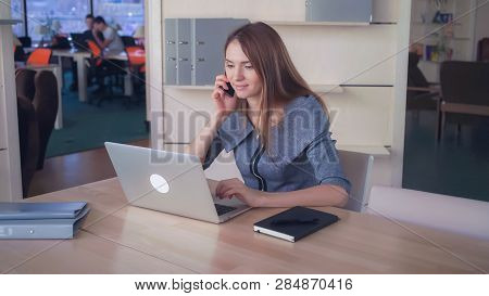 Businesswoman Using Mobile Phone In The Office To Commmunicate With A Call Receiver