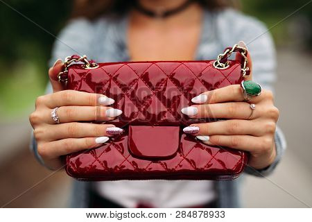 Trendy Woman With Beautiful Manicure Holding Red Handbag.