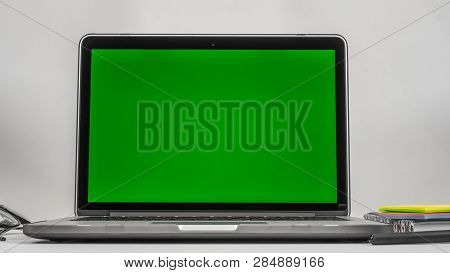 Office Workplace. Laptop, Notebook, Daily Planner, Glasses And Phone On White Background. Green Back