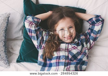 Happy 9 Years Old Kid Girl Relaxing On Bed In Weekend Morning. Smiling Preteen Girl At Home.