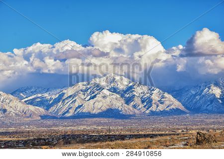 Winter Panoramic View Of Snow Capped Wasatch Front Rocky Mountains, Great Salt Lake Valley And Cloud