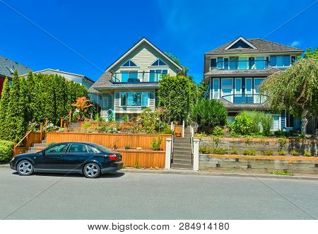 Suburban Family Houses With Landscaped Terraces A Car Parked In Front On Blue Sky Background
