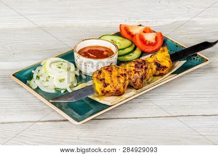 Skewers, Onions, Pita Bread, Sauce On A White Plate