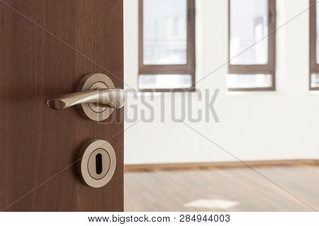Half Opened Door To A Ampty Room. Door Handle, Door Lock. Welcome, To New Home Concept