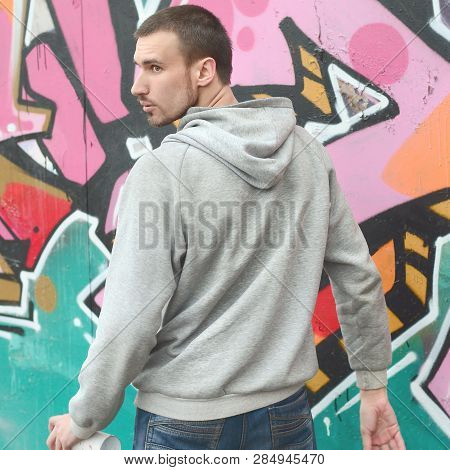 A Young Graffiti Artist Looks Around While Drawing. Vandal Tries