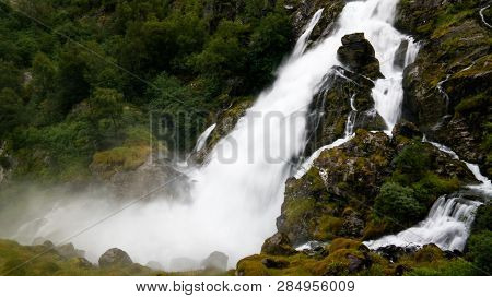 Panoramic View To Kleivafossen Waterfall On Briksdalselva River, Briksdalsbreen Glacier, Norway
