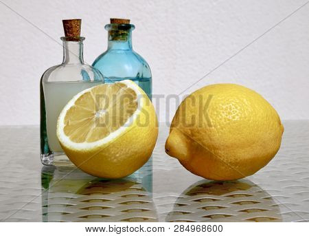 Still Life With Two Ripe Juicy Lemons And Cold Fresh Lemonade In Two Small Vintage Glass Botlles Aga