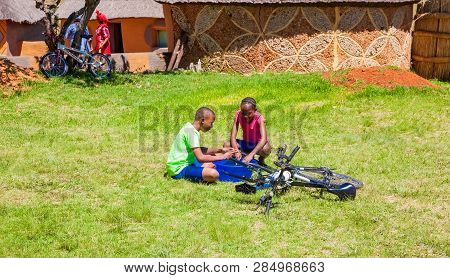 African Children Fixing A Puncture On A Bike