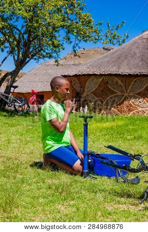 African Children Fixing A Puncture On A Bike