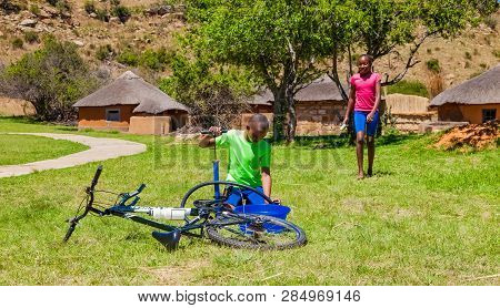 African Children Fixing A Puncture On A Bike