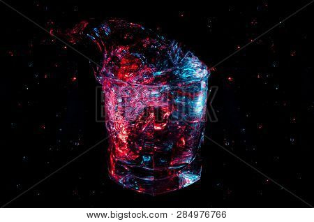 Big Colorful Splash From A Rocks Glass Isolated On A Black Background
