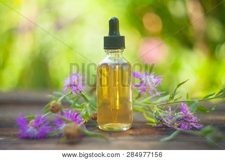 Essence Of Lavender Flowers On Table In Beautiful Glass Bottle